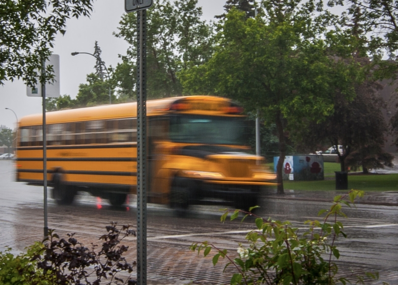 Yellow school bus on road during rain